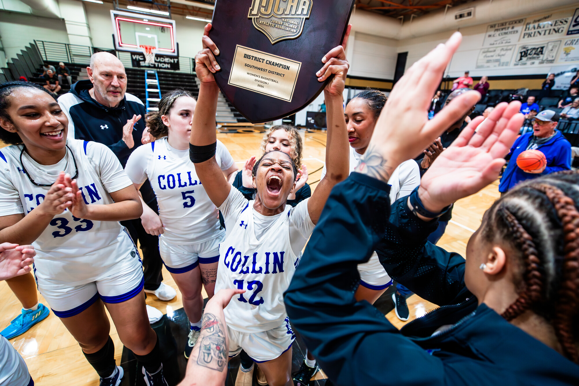 Alisha Nunley holds up the NJCAA Division I Southwest District Tournament plaque awarded to the Collin College Lady Cougars after winning the Region V tournament in Weatherford, March 16.