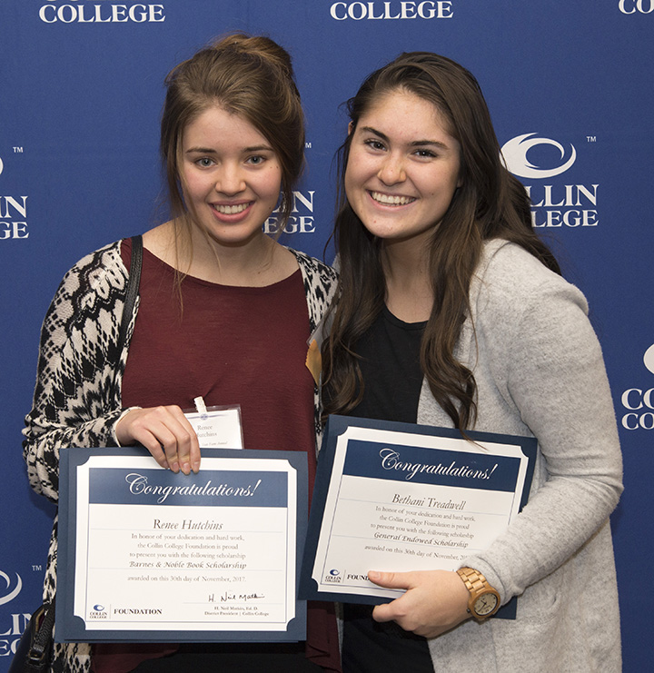 Two girls holding certificates