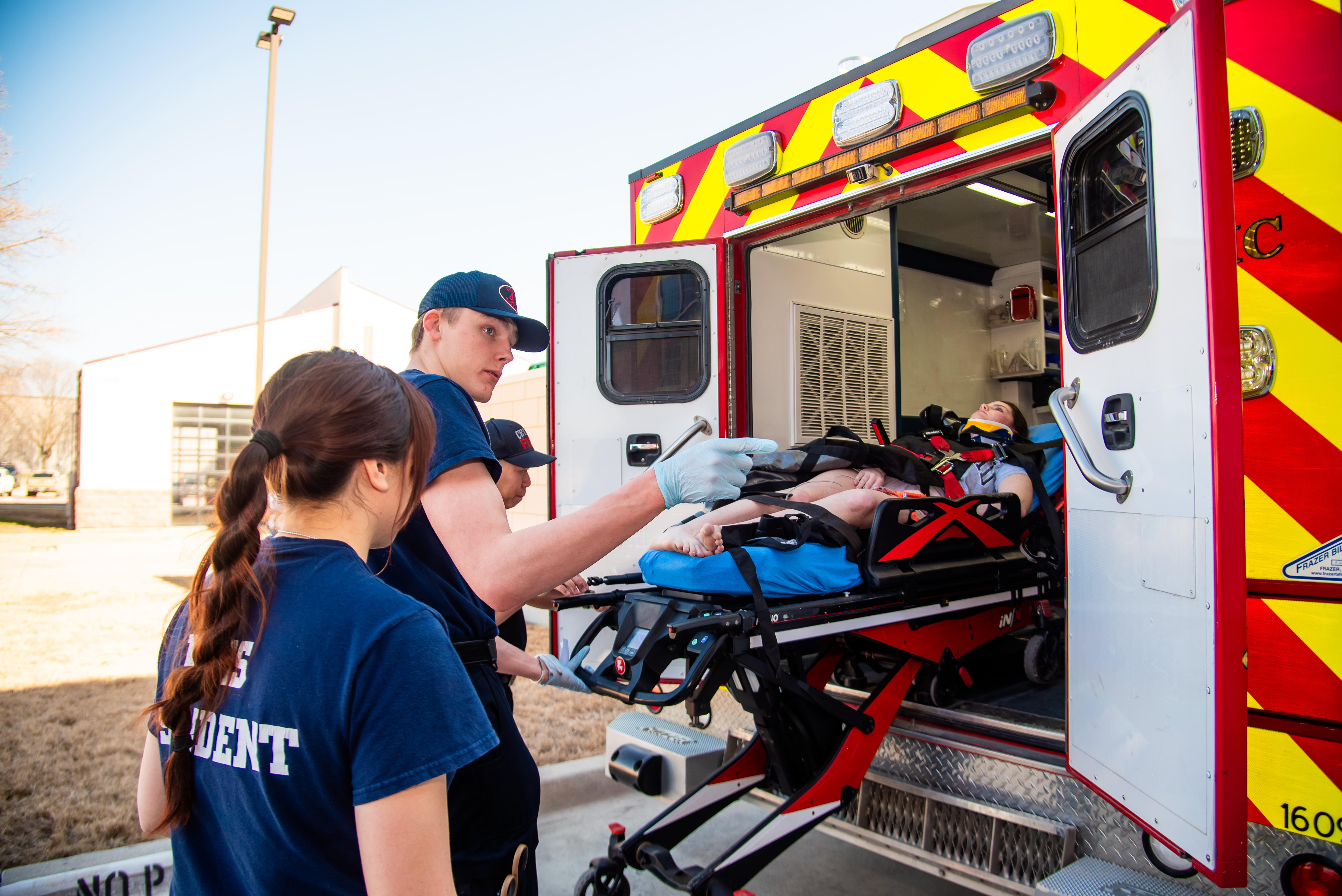 EMS Students doing a drill and loading a patient onto an ambulance