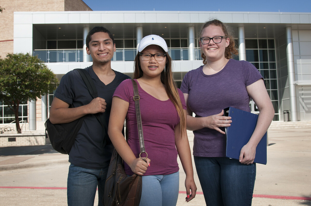Allen High School students standing outside school smiling and facing camera.