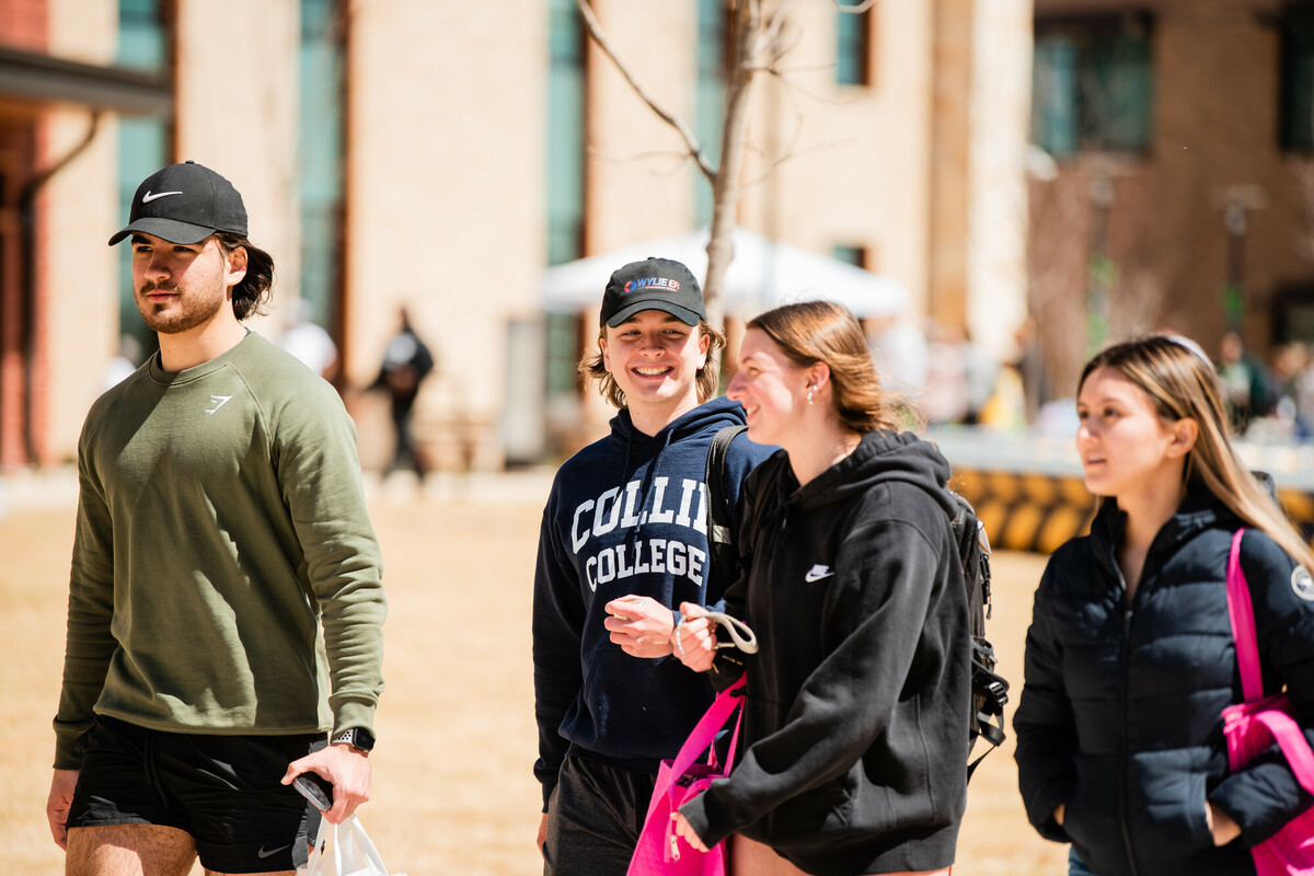 student outside at a booth for an on-campus activity