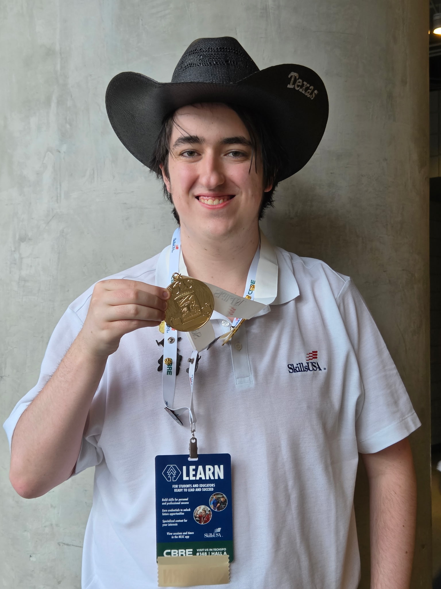 Student holding gold medal.